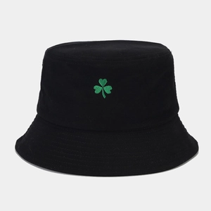 Détail de la broderie trèfle vert sur un chapeau bob en coton noir avec texture sergé