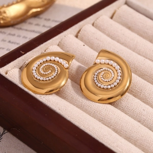 Detail of 18K gold snail earrings with spiral pearls on jewelry box background