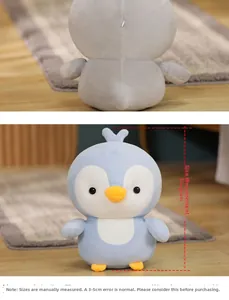 Close-up of soft plush penguin dolls in blue and grey showing fabric texture and orange details