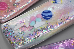 Detail of holographic space pencil case with quicksand glitter and planet patches