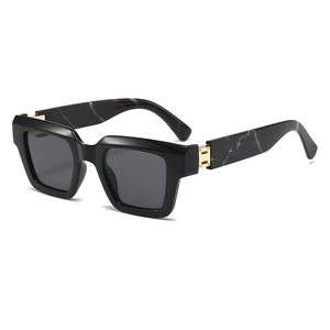 Detail of square sunglasses featuring marble patterns and a gold H-shaped metal hinge