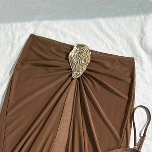 Detail of chocolate brown bikini with pleated fabric and a large gold metal buckle