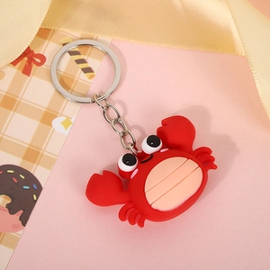 Close-up of a cute red silicone crab keychain featuring a round body and silver metal ring