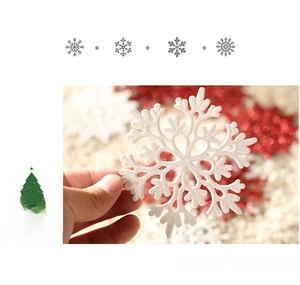 Detail of 10cm white glitter snowflake ornament being held to show realistic scale