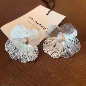 French vintage silver flower earrings with textured petals and center pearl on wood