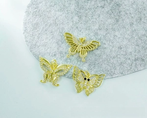 Macro detail of three 18K gold plated butterfly charms with micro-paved cubic zirconia
