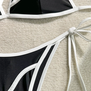 Detailed close-up of bikini top and bottom featuring white contrast trim and side ties