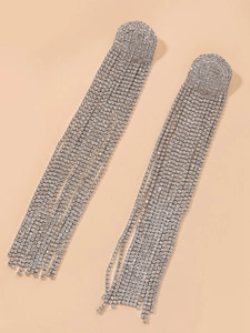 Vue macro de boucles d'oreilles argentées étincelantes avec longs pompons en strass