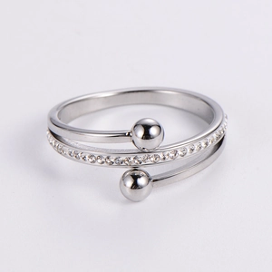 Silver multi-layer spiral ring with pavé diamonds and metal beads on plain background
