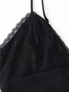 Close-up of intricate black floral lace pattern and adjustable strap on the V-neck dress