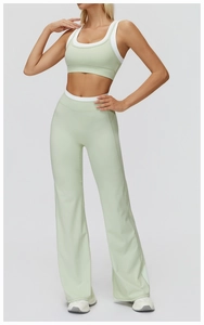 Detail view of mint green flared yoga pants and ribbed sports bra with white contrast trim