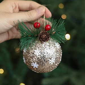 Golden Christmas ball ornament with white snowflakes and natural pine cone details