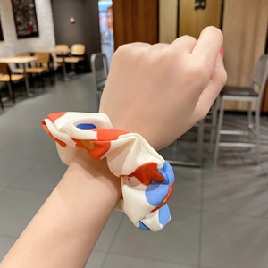 Floral print chiffon scrunchie with large orange and blue flowers on cream base