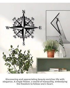 Detail of black metal compass wall art with N S E W letters on white wall