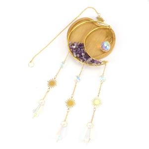 Golden moon suncatcher with purple crystal chips and prisms on a wooden tray