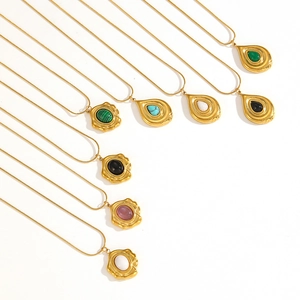 Detail of vintage gold snake chains with colorful turquoise and tiger eye pendants