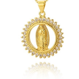 Macro shot of gold Guadalupe pendant with shimmering zircon pavé on a white surface