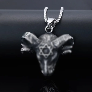 Gros plan du pendentif tête de bélier en argent avec hexagramme sur fond sombre