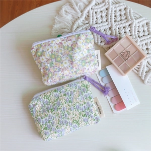 Détail de pochettes en coton à fleurs avec glands pour pièces et rangement rouge à lèvres