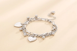 Detail view of silver double-layered stainless steel bracelet with heart pendant and beads