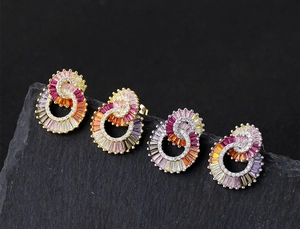 Macro shot of 925 silver double ring earrings with colorful zircon on black rock background