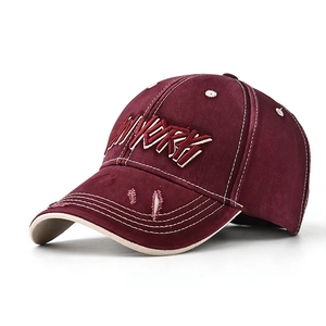 Detail of embroidered NEW YORK letters and distressed brim on burgundy baseball cap