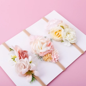 Set of three floral baby headbands with soft nylon bands in pink, peach, and yellow tones