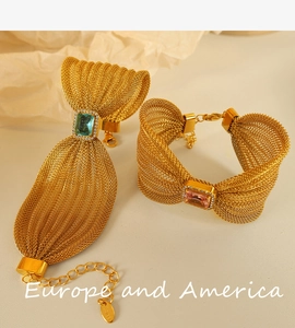 Detail of gold mesh bracelets with bow design and vibrant colored square gemstones