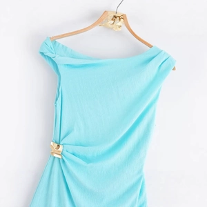 Robe midi asymétrique bleu clair en tissu gaufré avec boucle dorée élégante à la taille