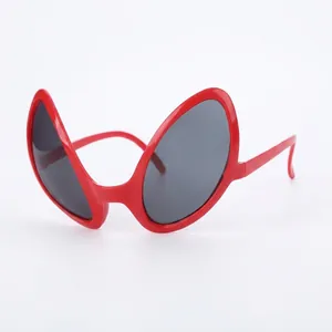 Macro detail of red alien-eye party sunglasses with dark grey oval lenses for fun events