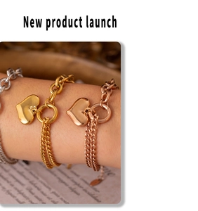 Detail of 18k gold heart pendant bracelet with double-layer chain on woman's wrist