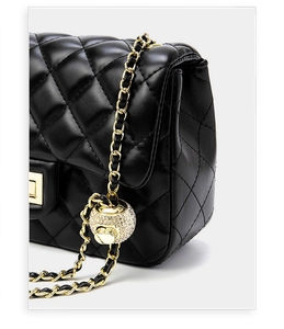 Detail of quilted leather bag with gold chain strap and sparkling crystal ball buckle