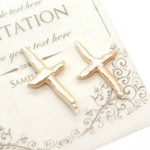 Detailed view of two natural baroque cross pearls on a vintage background card