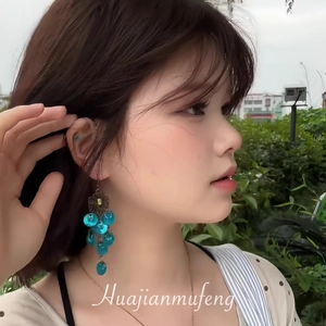 Close-up of bohemian blue beaded tassel earrings worn by a model in outdoor setting