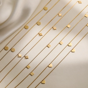 Layered 18K gold plated stainless steel necklaces with geometric pendants on silk
