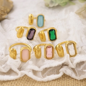 Bagues ajustables plaquées or 18K avec zircons colorés sur fond de dentelle blanche