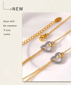 Detail of 18k gold plated stainless steel bracelet with hollow silver heart pendant