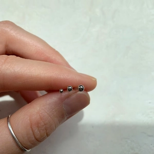 Detailed comparison of three graduated S925 sterling silver ball stud earrings in hand