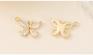 Detail view of gold butterfly pendant featuring clear cubic zirconia and rear metal base