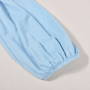 Détail du poignet élastique bleu clair et de la texture en maille fine du vêtement