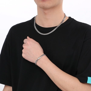 Ensemble collier et bracelet gourmette bicolore argent et or pour homme sur fond blanc