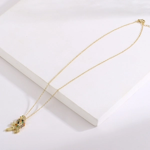 Dettaglio della collana con ciondolo a pappagallo dorato e zirconi colorati micro-pave
