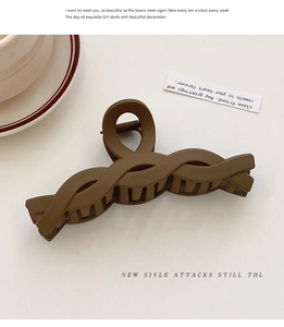 Detail view of large matte brown twist hair claw clip with strong metal spring