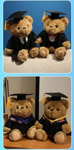 Detail of graduation teddy bears in black academic gowns with floral embroidery accents