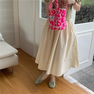 Pink leopard print tote bag paired with white skirt and green bow flats in a lifestyle view