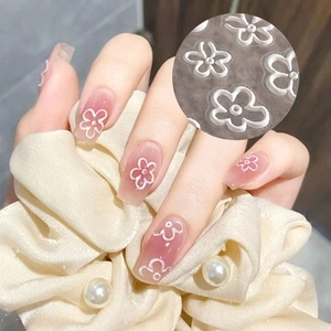 Close-up of 5D floral nail stickers with pink base and white embossed flower details