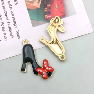 Detail of high heel metal charms with red polka dot bow and golden trim for DIY jewelry