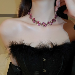 Detail of luxury necklace with purple gems and clear rhinestones on model neck