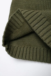 Dettaglio macro dell'orlo del maglione in maglia verde militare con trama a costine