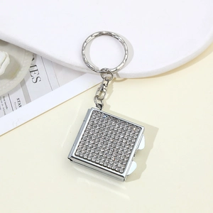 Macro shot of square rhinestone-encrusted keychain pendant with sparkling crystals